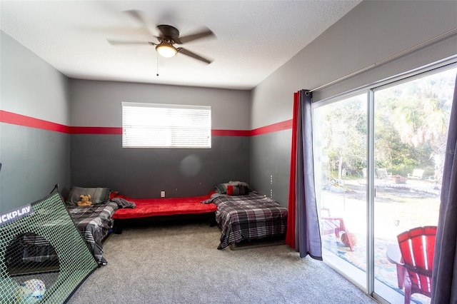 bedroom featuring access to exterior, ceiling fan, carpet, and a textured ceiling