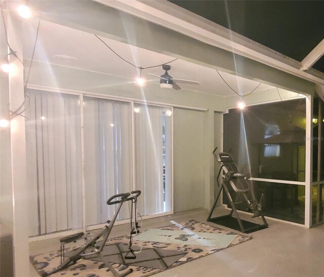 exercise room with ceiling fan and wooden walls