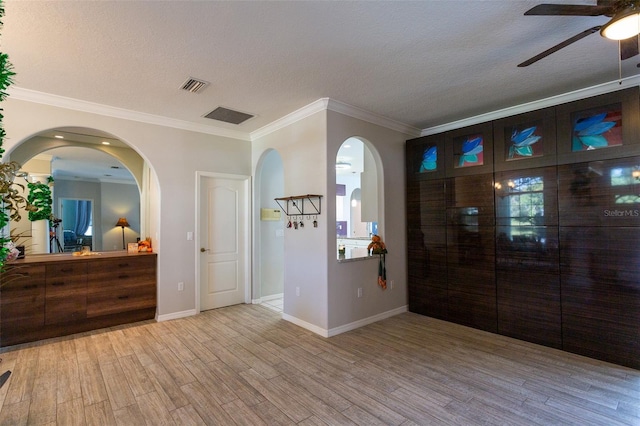 foyer featuring ceiling fan, light hardwood / wood-style floors, crown molding, and a textured ceiling