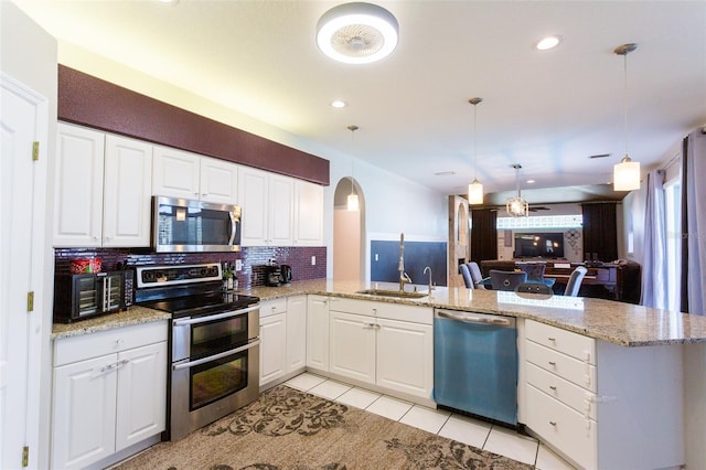 kitchen with stainless steel appliances, white cabinetry, and kitchen peninsula