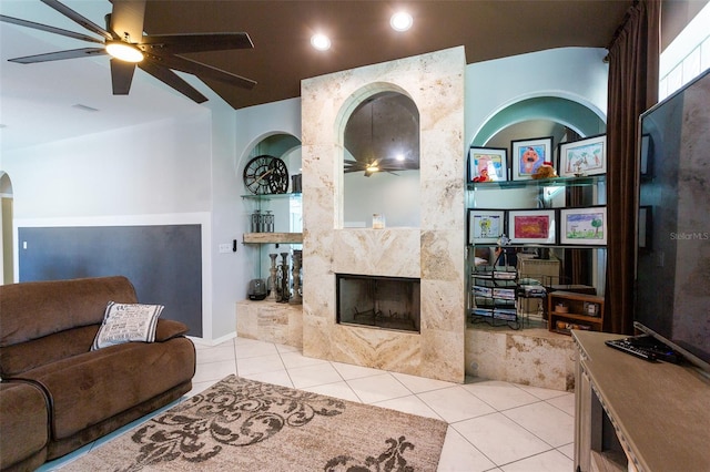 living room featuring a fireplace, ceiling fan, built in features, and light tile patterned floors