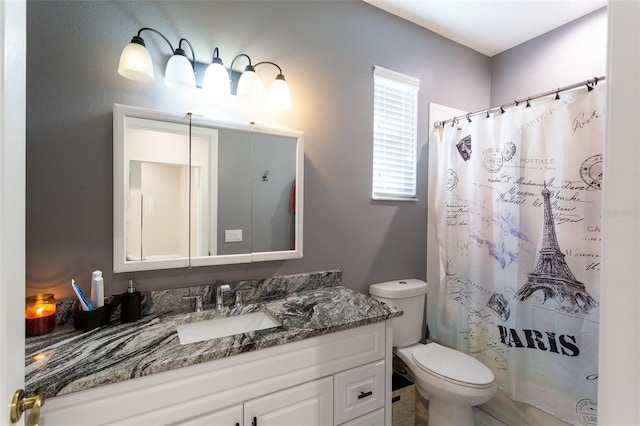 bathroom featuring toilet, vanity, and walk in shower