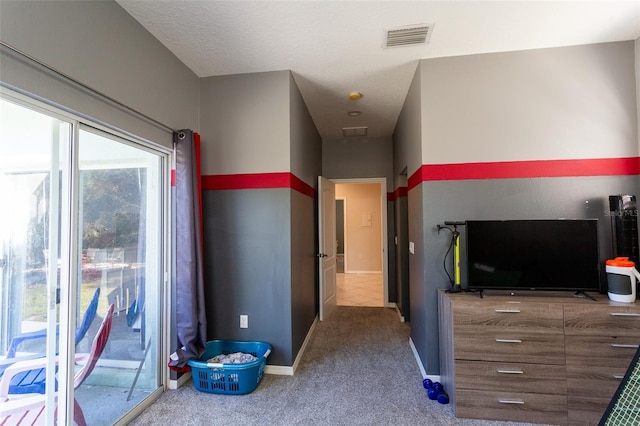 unfurnished bedroom featuring carpet flooring, access to exterior, and a textured ceiling