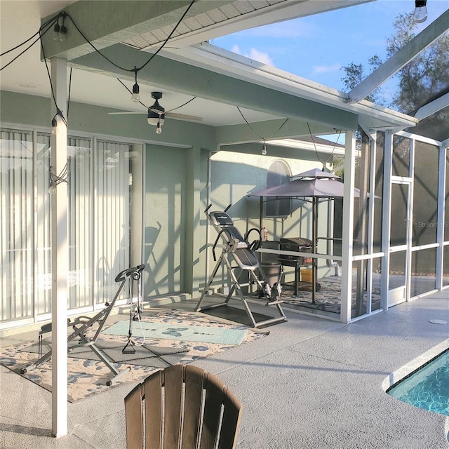 exterior space featuring glass enclosure and ceiling fan