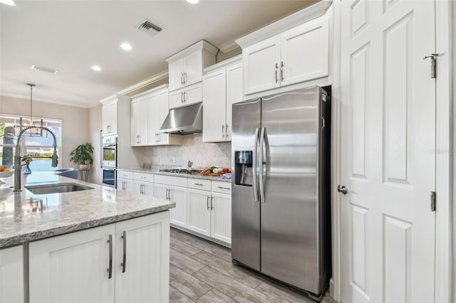 kitchen featuring light stone countertops, ornamental molding, stainless steel appliances, sink, and white cabinets