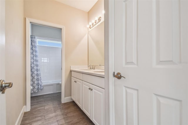 bathroom featuring shower / bath combination with curtain, vanity, and hardwood / wood-style flooring