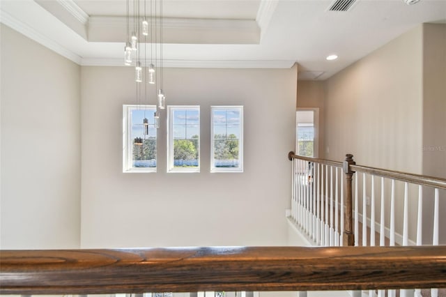 interior details featuring a tray ceiling and ornamental molding