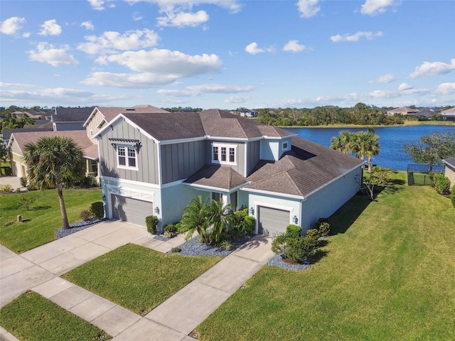 view of front of home featuring a water view, a front yard, and a garage