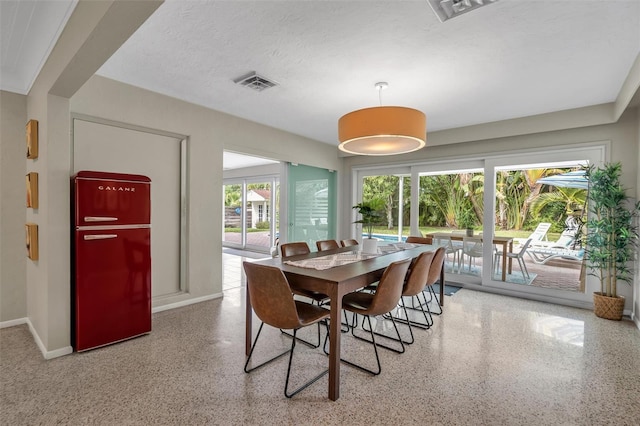 dining room featuring a textured ceiling and a wealth of natural light