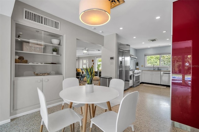 dining room with ceiling fan and sink