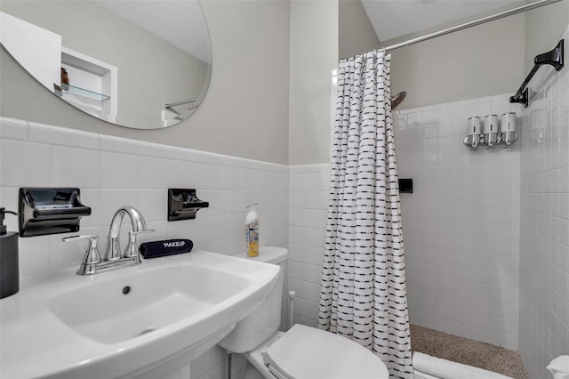 bathroom with toilet, tile walls, curtained shower, and sink