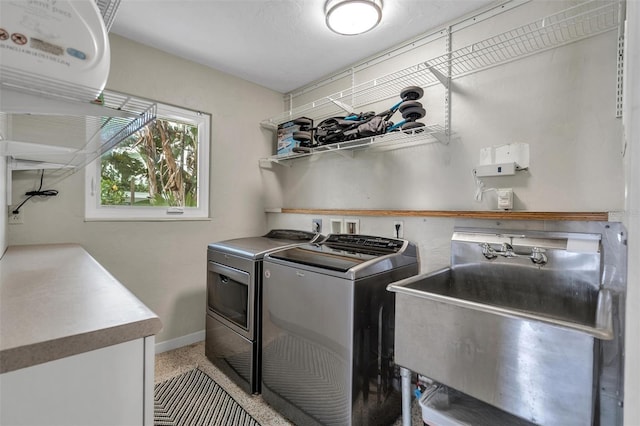 laundry room with separate washer and dryer and sink