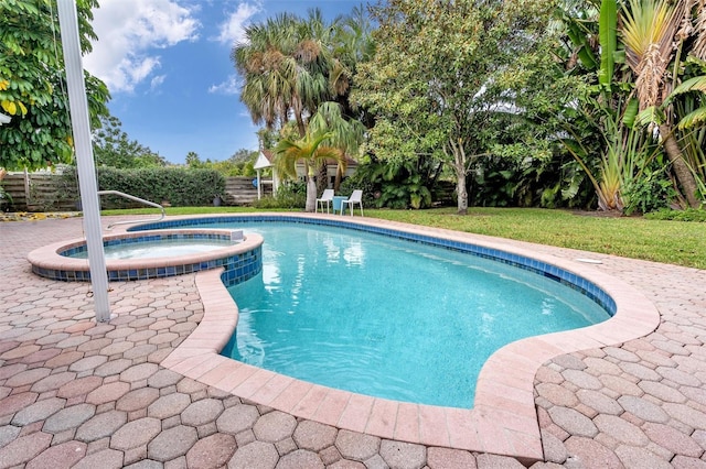 view of pool featuring a lawn, an in ground hot tub, and a patio