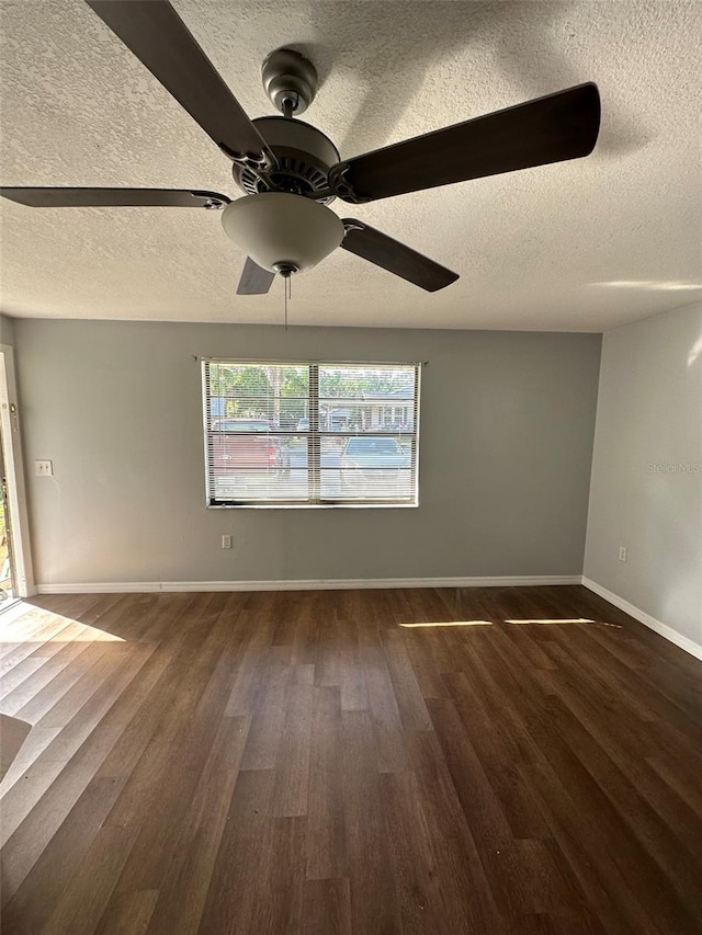 spare room featuring ceiling fan, dark wood-type flooring, and a textured ceiling