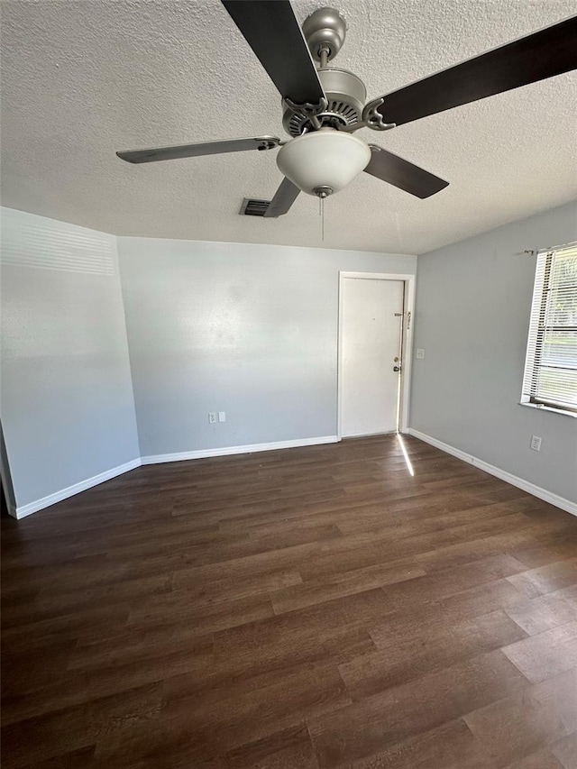 spare room featuring a textured ceiling, ceiling fan, and dark wood-type flooring