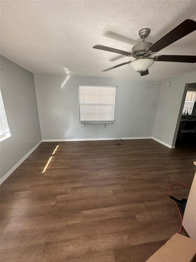 unfurnished room featuring dark hardwood / wood-style flooring, a textured ceiling, and a wealth of natural light