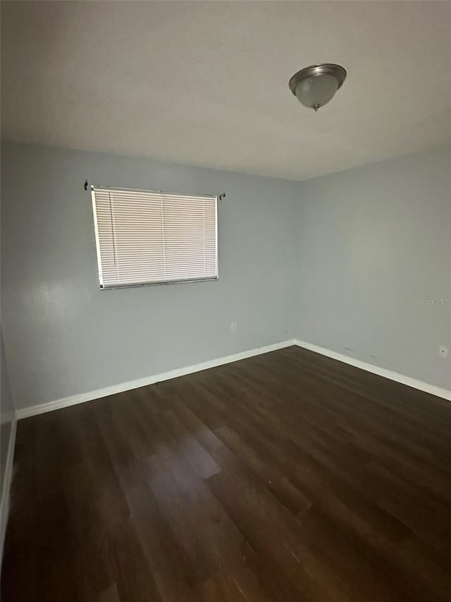 spare room featuring dark wood-type flooring