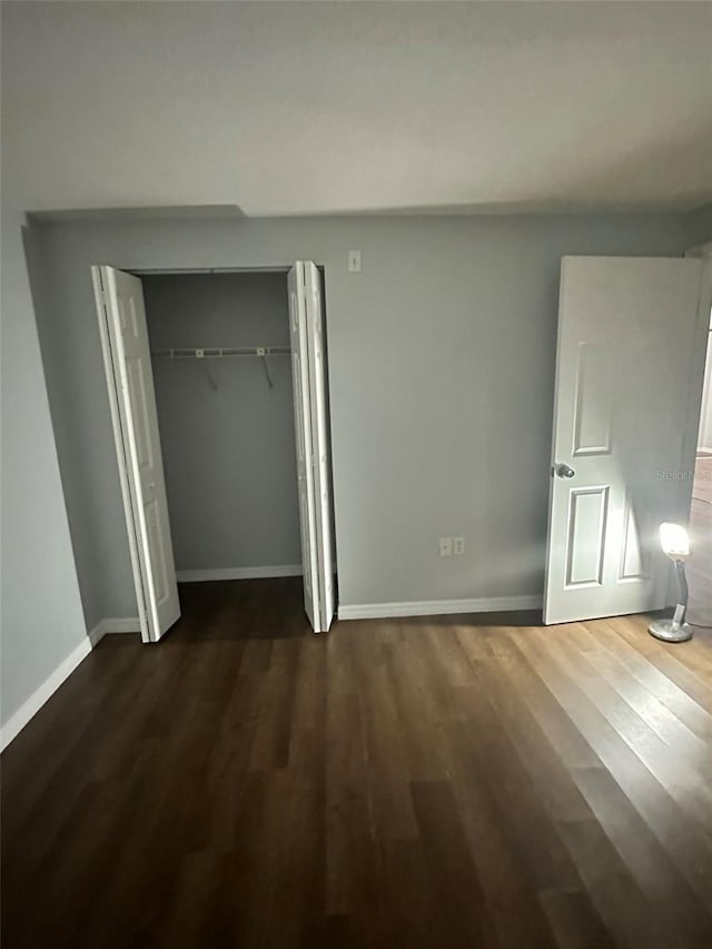 unfurnished bedroom with dark wood-type flooring