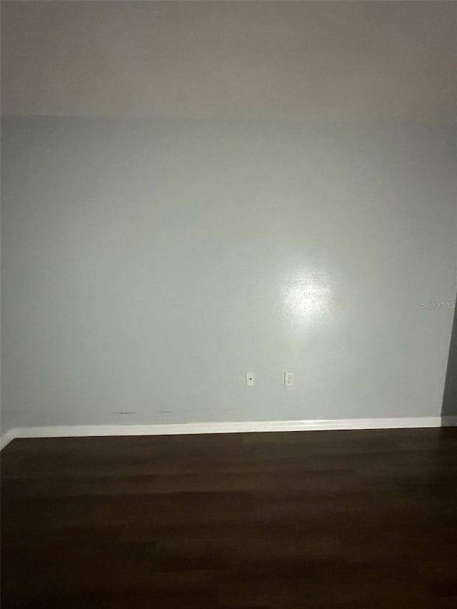 empty room with dark hardwood / wood-style floors