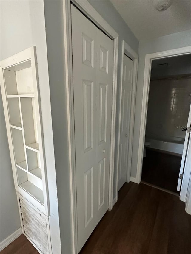 corridor with dark hardwood / wood-style floors