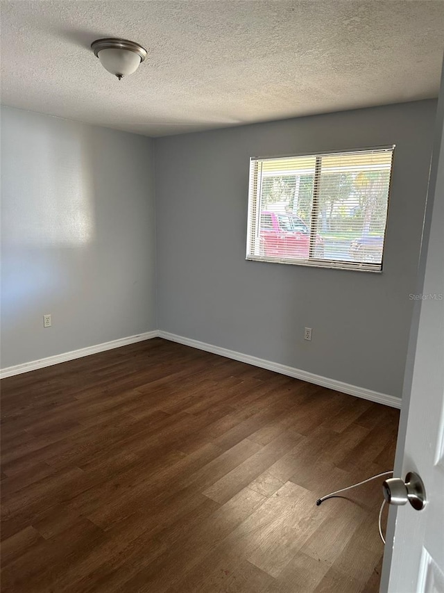 spare room featuring wood-type flooring and a textured ceiling