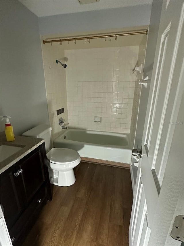 full bathroom with toilet, vanity, tiled shower / bath combo, and hardwood / wood-style flooring