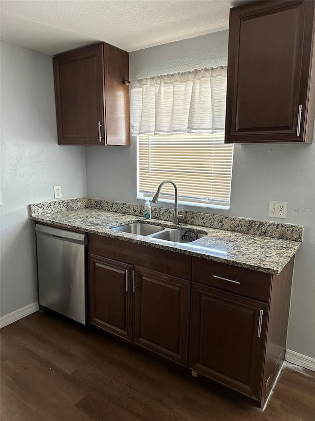 kitchen with sink, stainless steel dishwasher, light stone countertops, dark brown cabinets, and dark hardwood / wood-style flooring