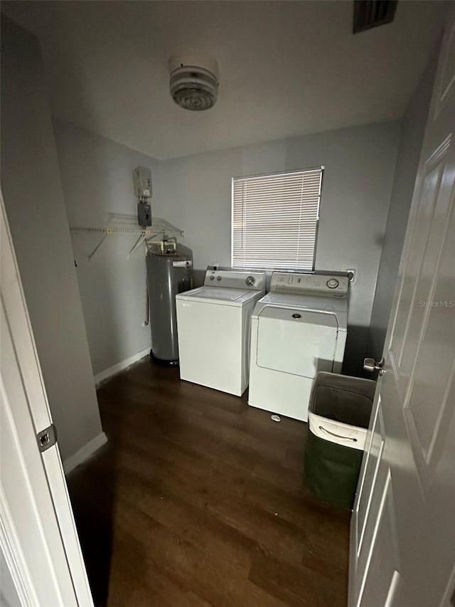 laundry room featuring independent washer and dryer, dark hardwood / wood-style flooring, and water heater