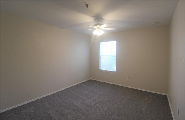 carpeted spare room featuring ceiling fan