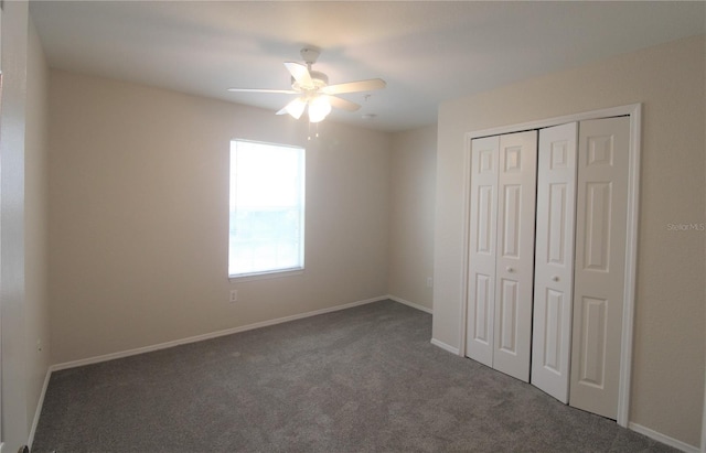 unfurnished bedroom featuring ceiling fan, a closet, and dark colored carpet