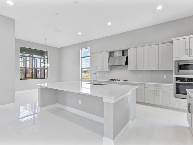 kitchen featuring an island with sink, sink, wall chimney exhaust hood, and stainless steel appliances