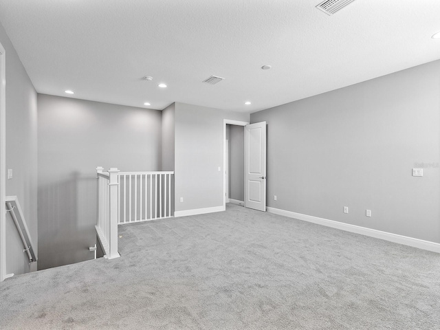 carpeted empty room with a textured ceiling