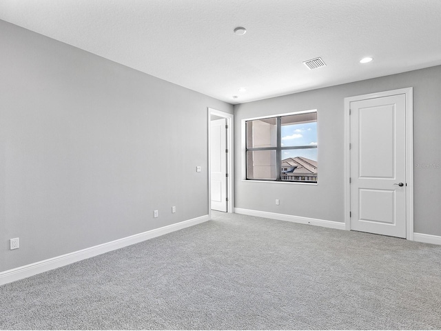 carpeted empty room featuring a textured ceiling