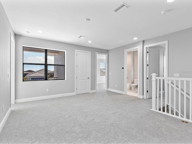 empty room with light carpet and a textured ceiling