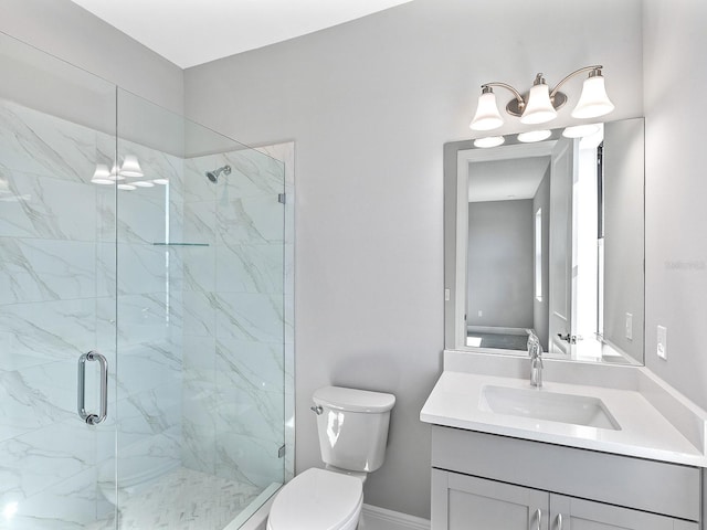 bathroom featuring vanity, toilet, and a shower with shower door