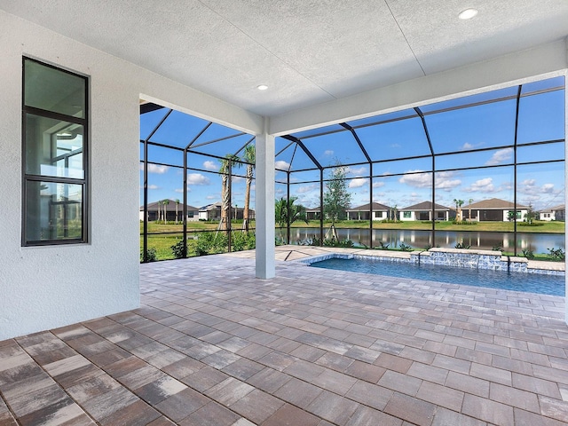 view of swimming pool featuring a lanai, a patio, and a water view