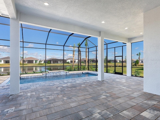 view of swimming pool featuring a water view, a patio area, and a lanai