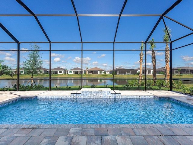 view of pool with glass enclosure, a water view, and a patio