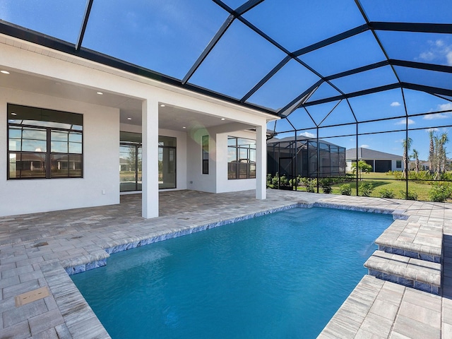 view of pool featuring glass enclosure and a patio area