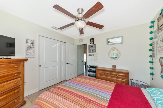 bedroom with light tile patterned floors, a closet, and ceiling fan