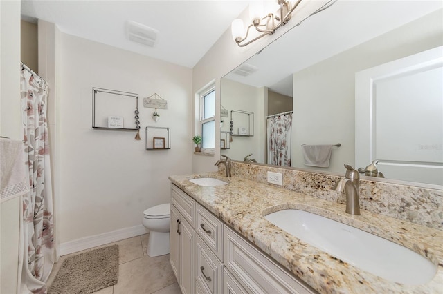 bathroom with toilet, vanity, and tile patterned floors