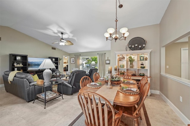 tiled dining space featuring ceiling fan with notable chandelier and lofted ceiling