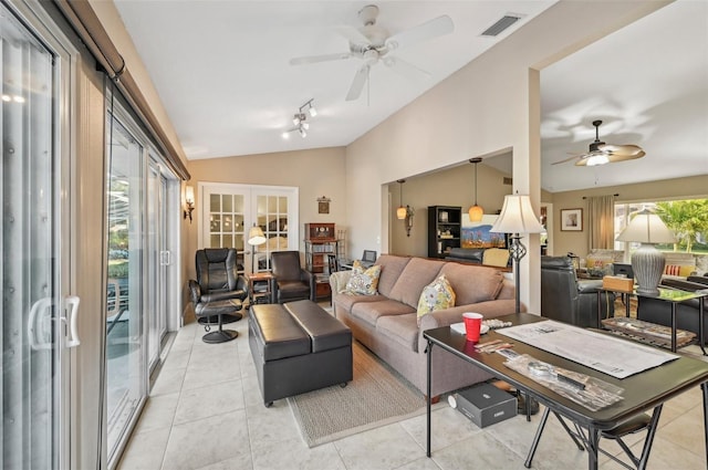 tiled living room with ceiling fan, french doors, and vaulted ceiling