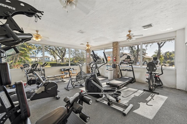 exercise room with a textured ceiling and ceiling fan