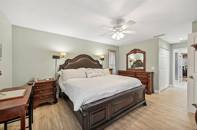 bedroom with ceiling fan, light hardwood / wood-style floors, and a closet