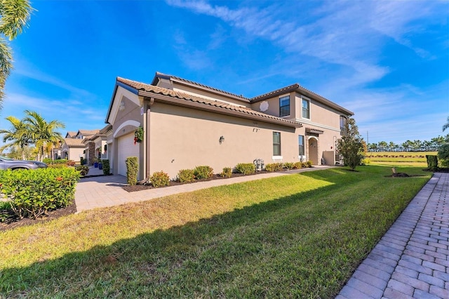 view of side of home featuring a lawn and a garage