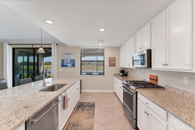 kitchen featuring decorative light fixtures, a wealth of natural light, sink, and appliances with stainless steel finishes