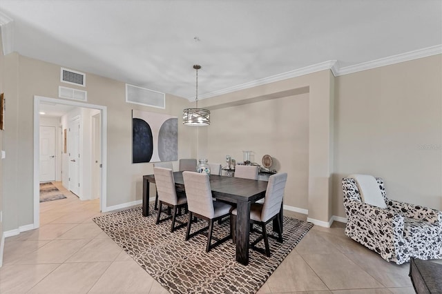 tiled dining room with a chandelier and crown molding