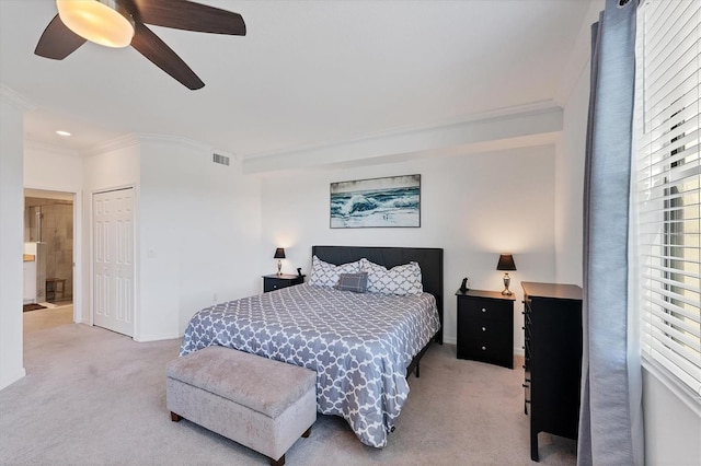 carpeted bedroom with a closet, ceiling fan, and crown molding