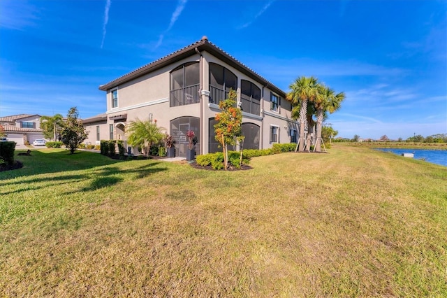 view of side of property with a water view and a yard